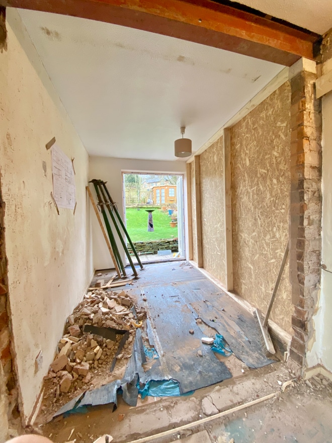 A room boarded up from the room that is being renovated. There is a double aptior door leding to the garden.